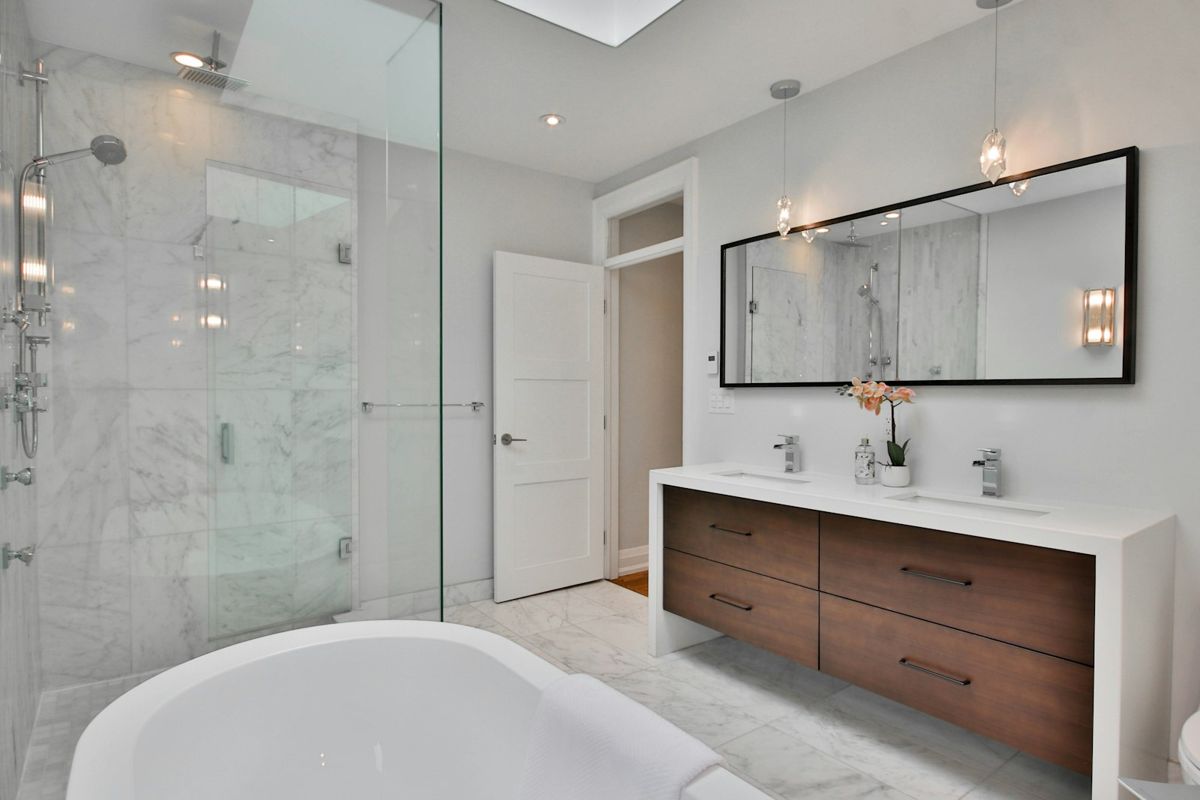 Bathroom with frameless glass shower, freestanding tub and walnut vanity