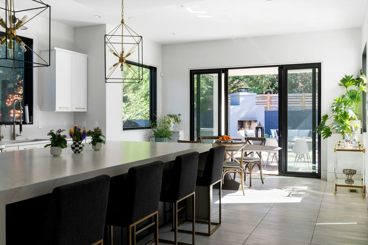 Modern dark kitchen with long island and black-framed glass doors