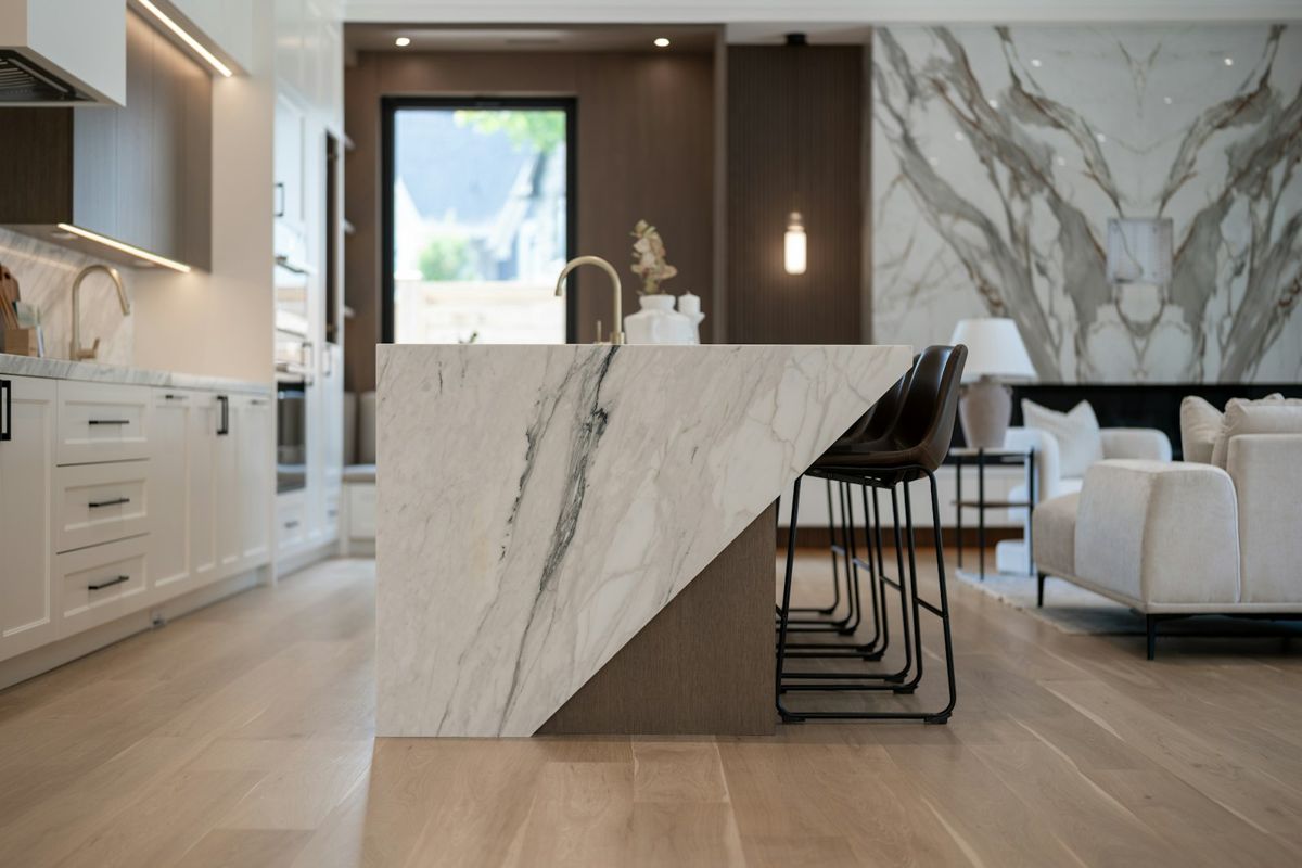 Kitchen with sculptural marble island and dark wood cabinetry