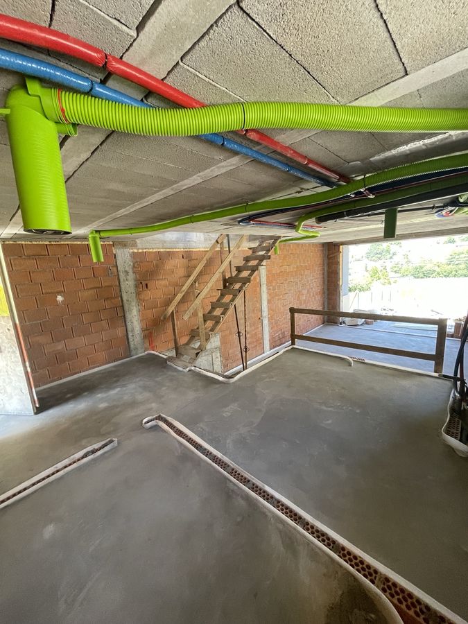 Leveled floor screed with plumbing, heating and ventilation ducts run under the slab